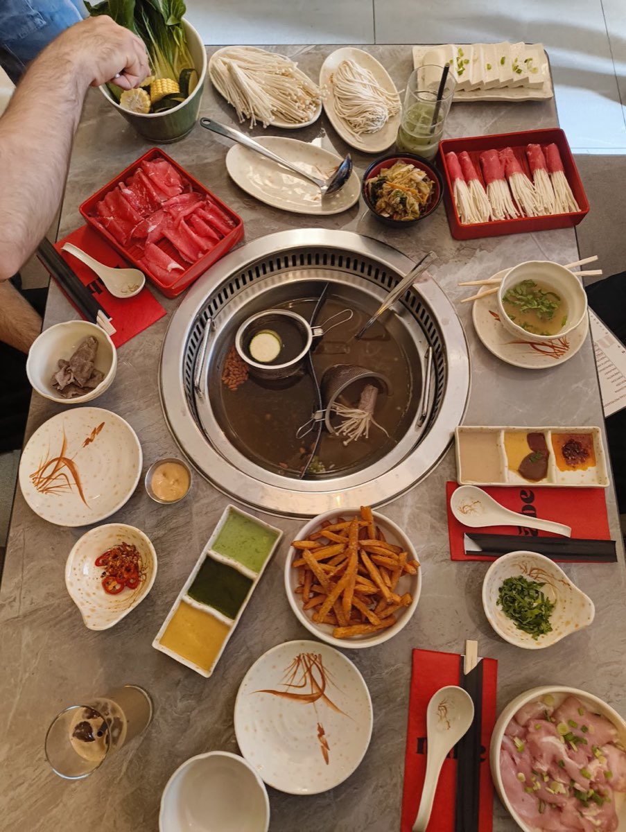 Rozłożony stół hotpot z talerzami mięsa i dodatków do dzielenia